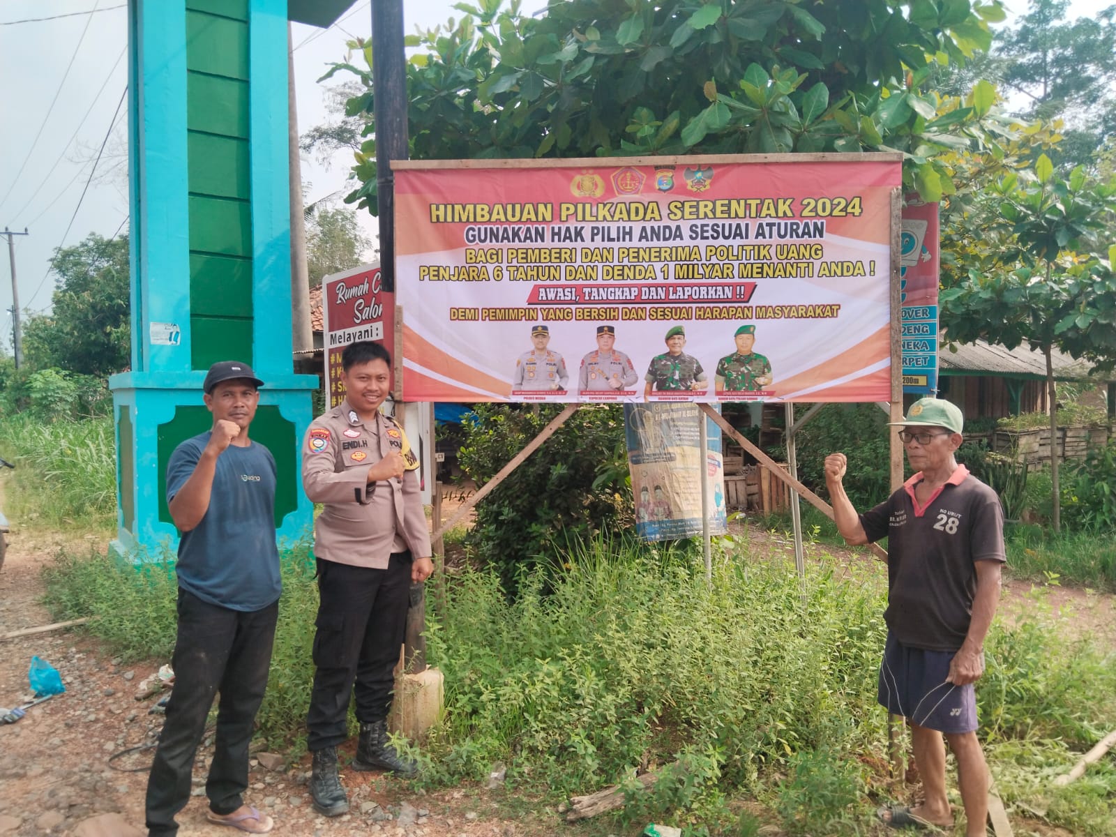 Bhabinkamtibmas Polsubsektor Mesuji Pusat Laksanakan Pemasangan Banner Himbauan Pilkada Damai 2024 di Depan Balai Desa Sidomulyo
