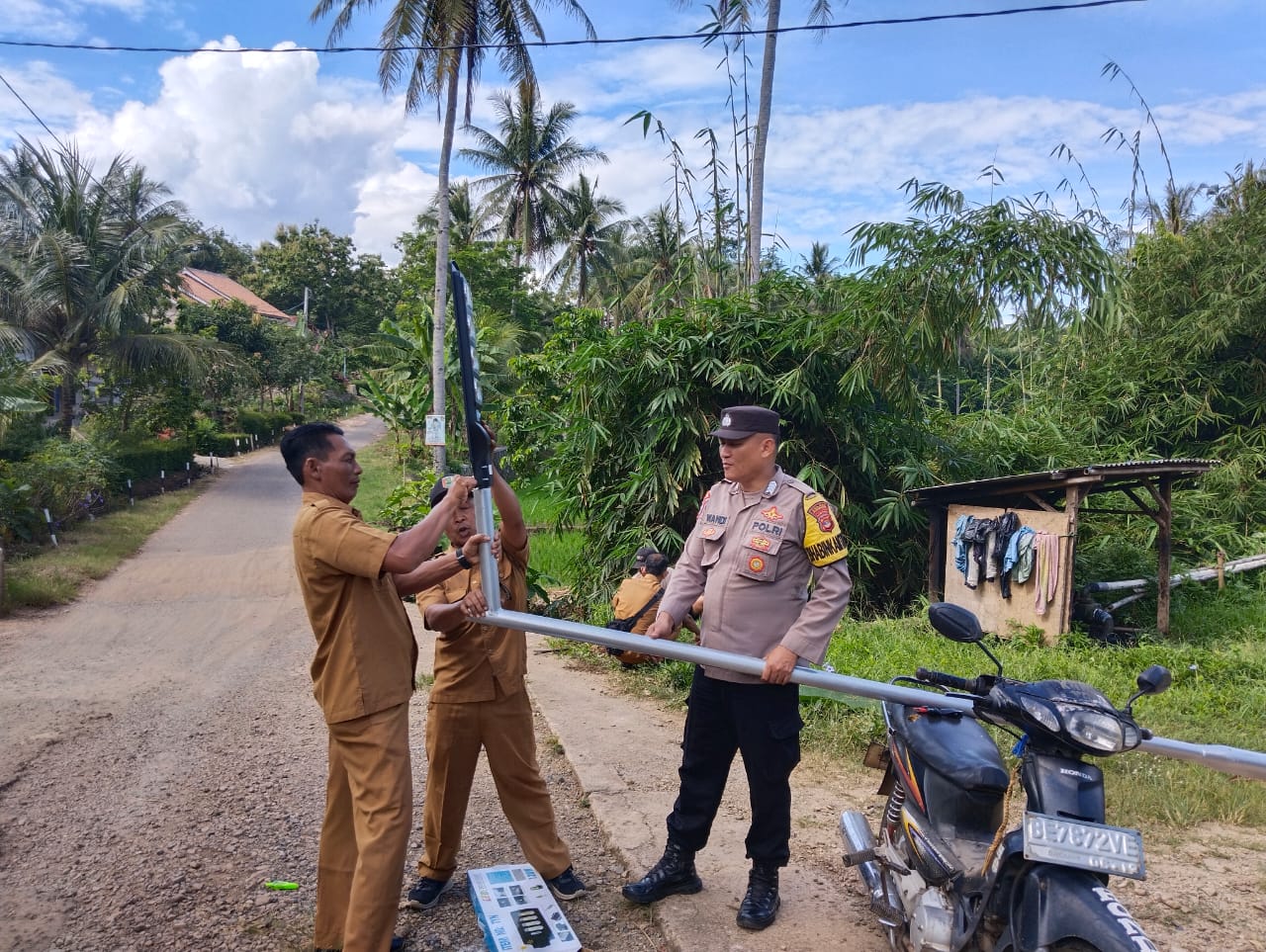 Bhabinkamtibmas Polsek Gedong Tataan Bersama Warga Pasang Lampu Jalan Tenaga Surya