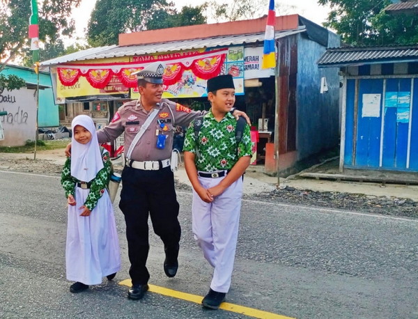 Satlantas Polres Lampung Barat Bantu Menyebrangkan Anak di waktu Jam Sibuk