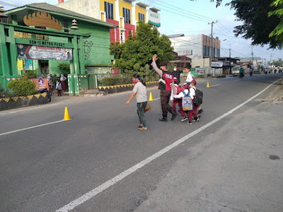 Wujud Kepedulian, Polisi Bantu Anak Sekolah Menyeberang Jalan